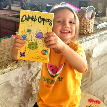 Child holding Cobweb Capers book